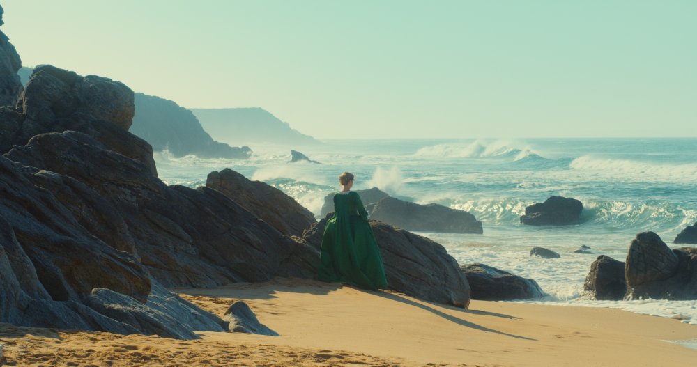 portrait-of-a-lady-on-fire-2019-002-woman-in-green-dress-against-rocky-shore-ORIGINAL