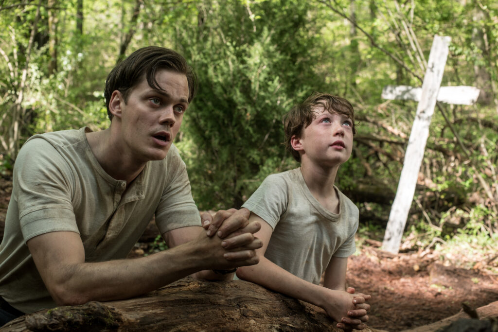 Bill Skarsgård as Willard and Michael Banks Repeta as Young Arvin